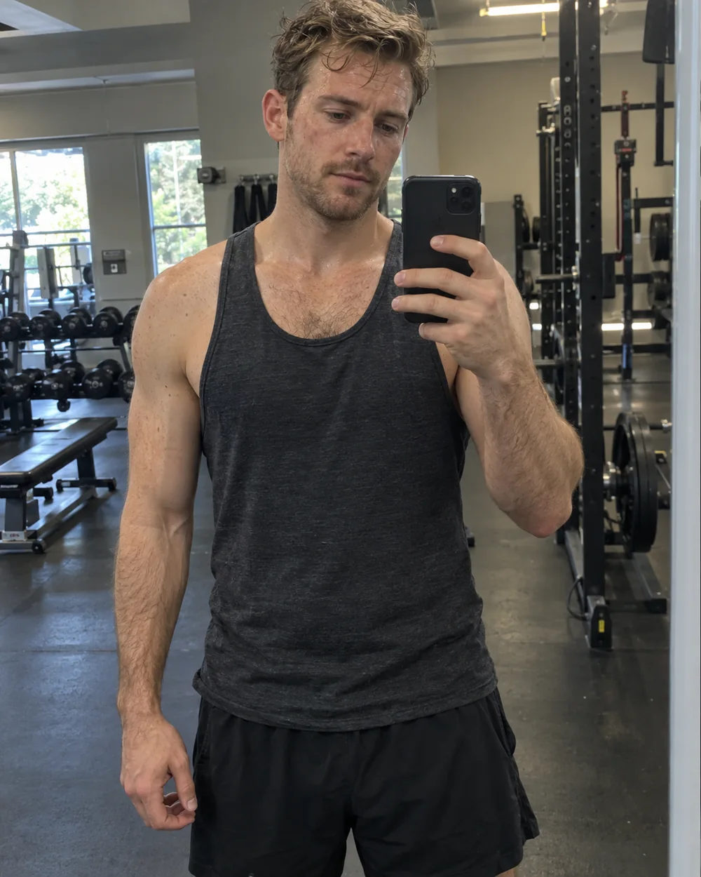 Illustrative adult male fitness creator taking a gym mirror selfie
